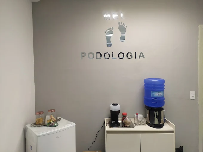 Recepção do consultório Mel Podologia, com a marca aplicada na parede